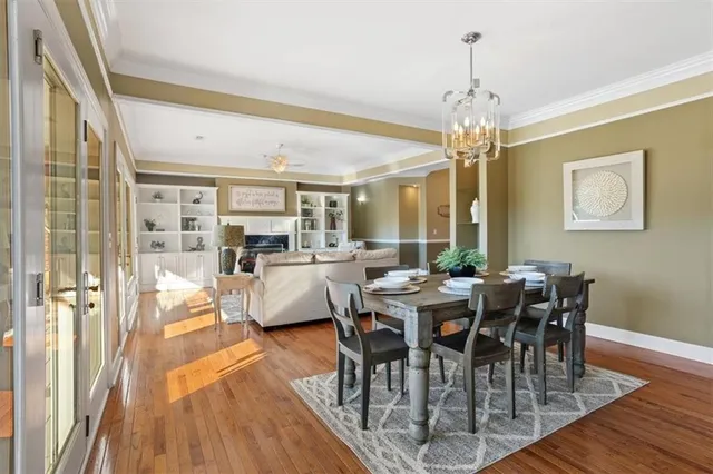 a kitchen that has a table chairs in it and wooden cabinets