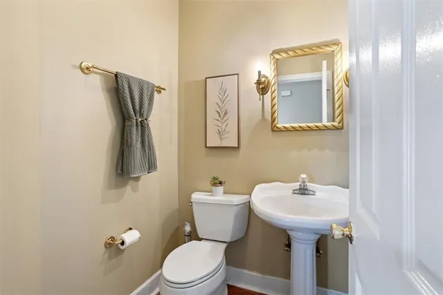 a living room with couches and kitchen view with wooden floor