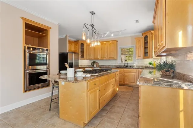 a bathroom with a granite countertop sink and a window