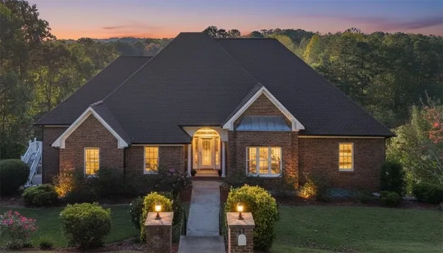 a view of a house with a big yard plants and large trees