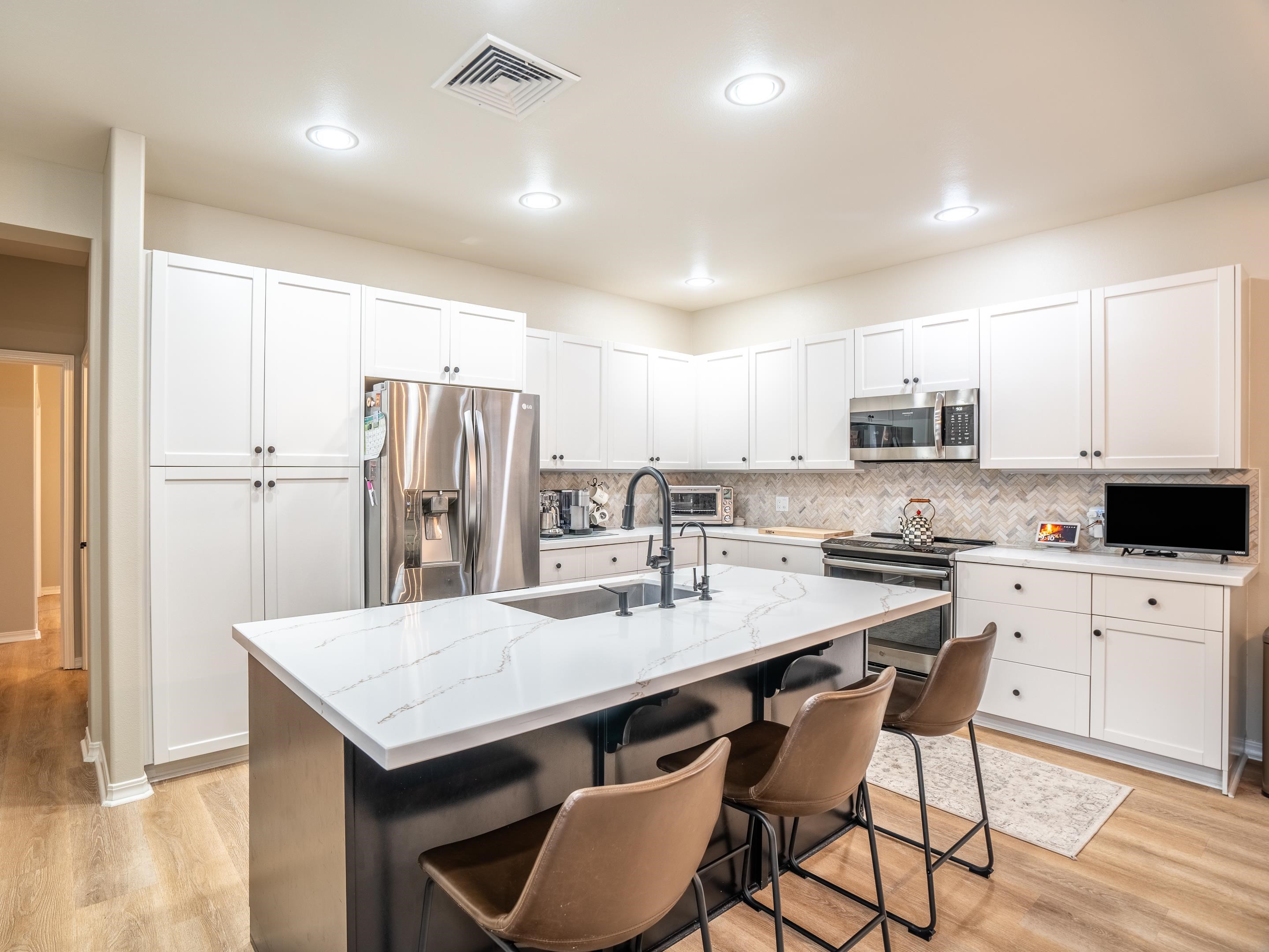 42 Maunaleo Place Wailuku, HI 96793 - Photo 13 of 36 a kitchen with stainless steel appliances a table chairs refrigerator and cabinets