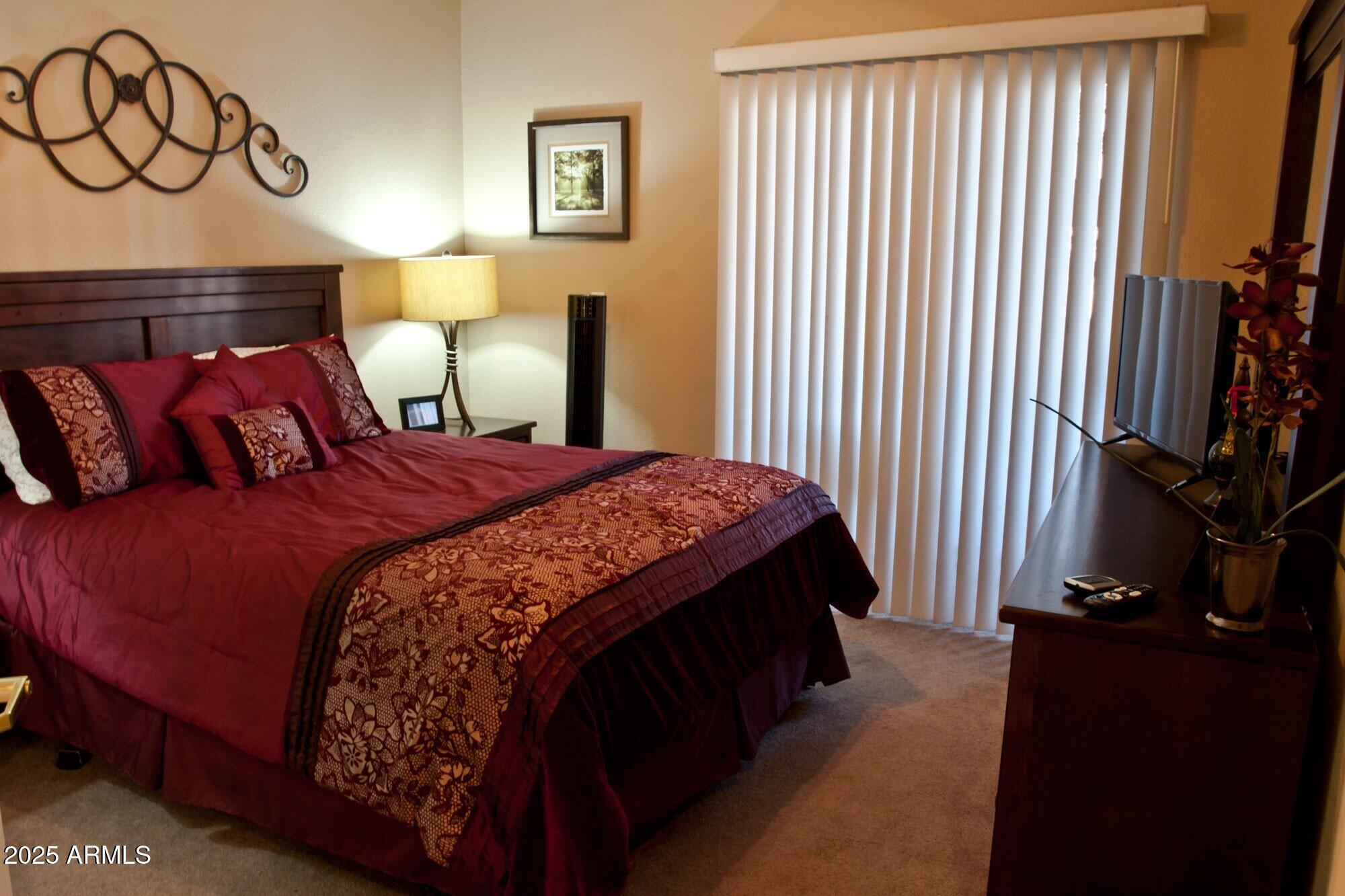 10030 West Indian School Road, Unit 164 Phoenix, AZ 85037 - Photo 14 of 16 a bedroom with a bed and a night stand