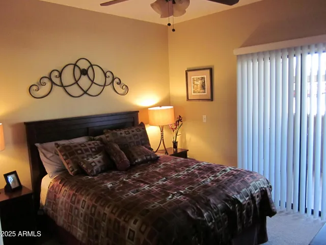 a bed sitting in a bedroom next to a lamp and a window