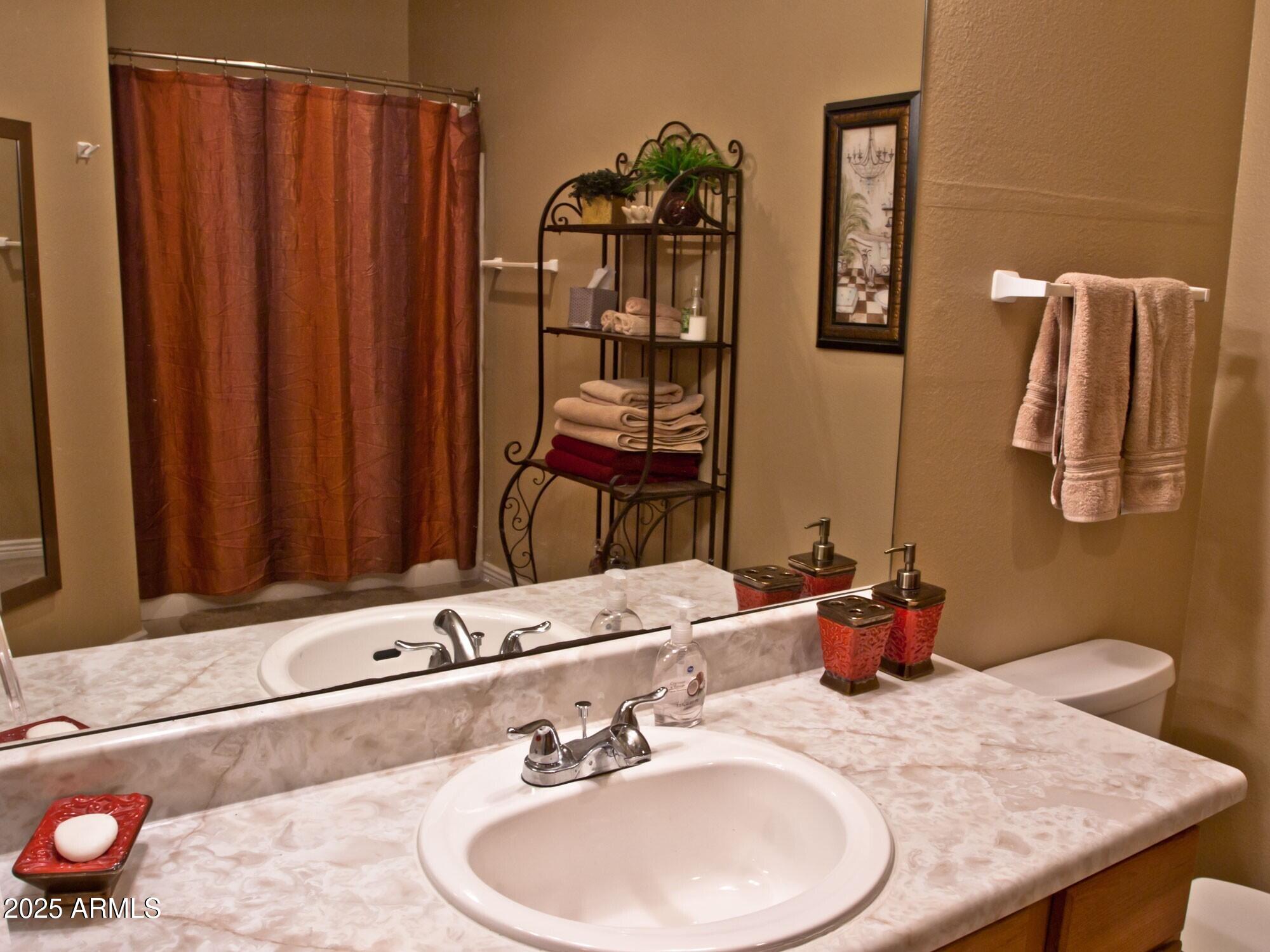 10030 West Indian School Road, Unit 164 Phoenix, AZ 85037 - Photo 16 of 16 a bathroom with a sink and a mirror