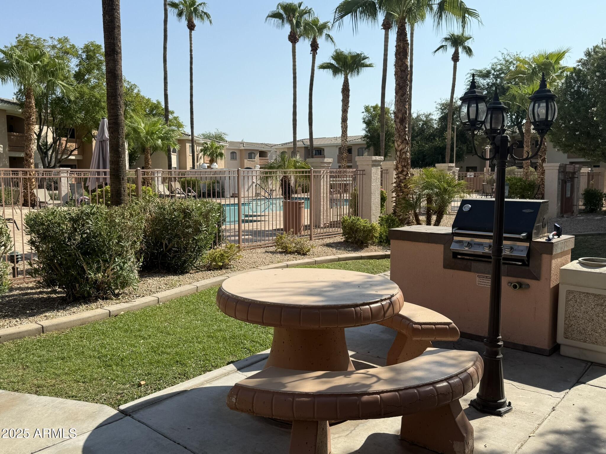 10030 West Indian School Road, Unit 164 Phoenix, AZ 85037 - Photo 7 of 16 a view of a backyard with a fountain plants and swimming pool