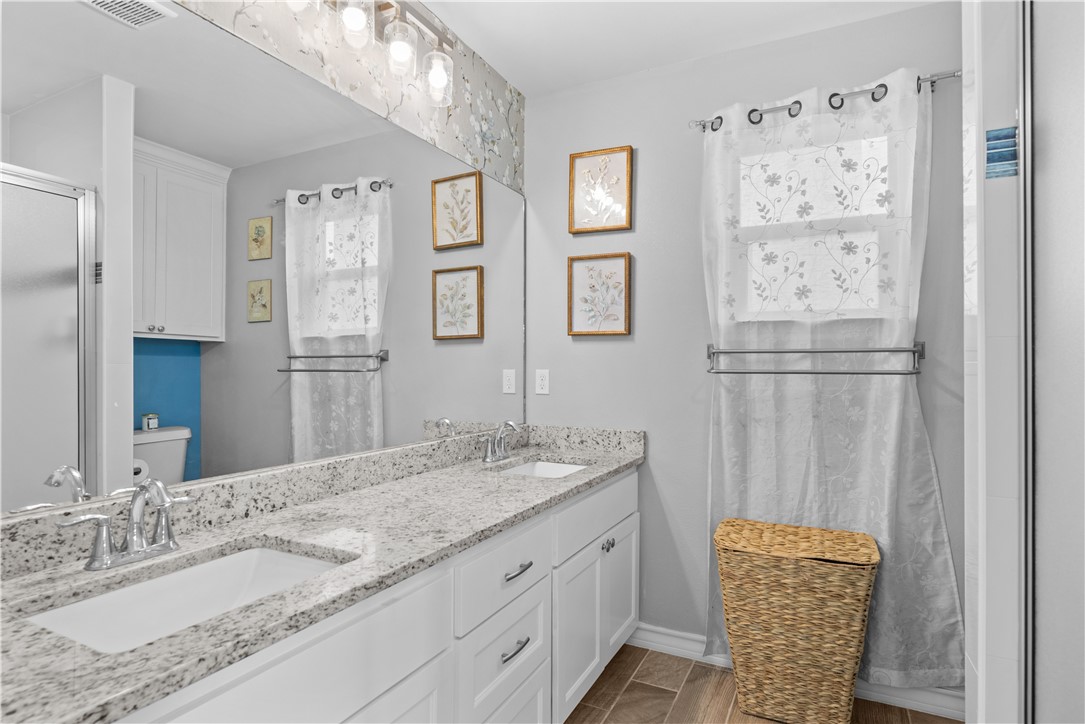 103 Atkinson Drive Orange Grove, TX 78372 - Photo 16 of 30 a bathroom with a granite countertop sink and a mirror