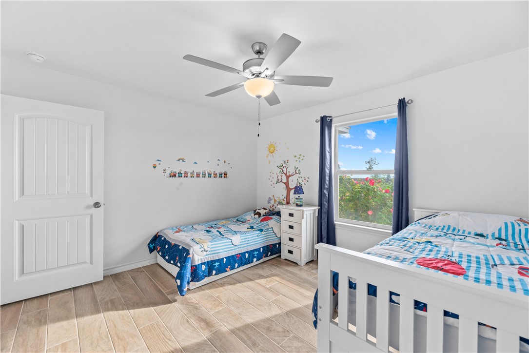 103 Atkinson Drive Orange Grove, TX 78372 - Photo 19 of 30 a bedroom with a bed and a chandelier