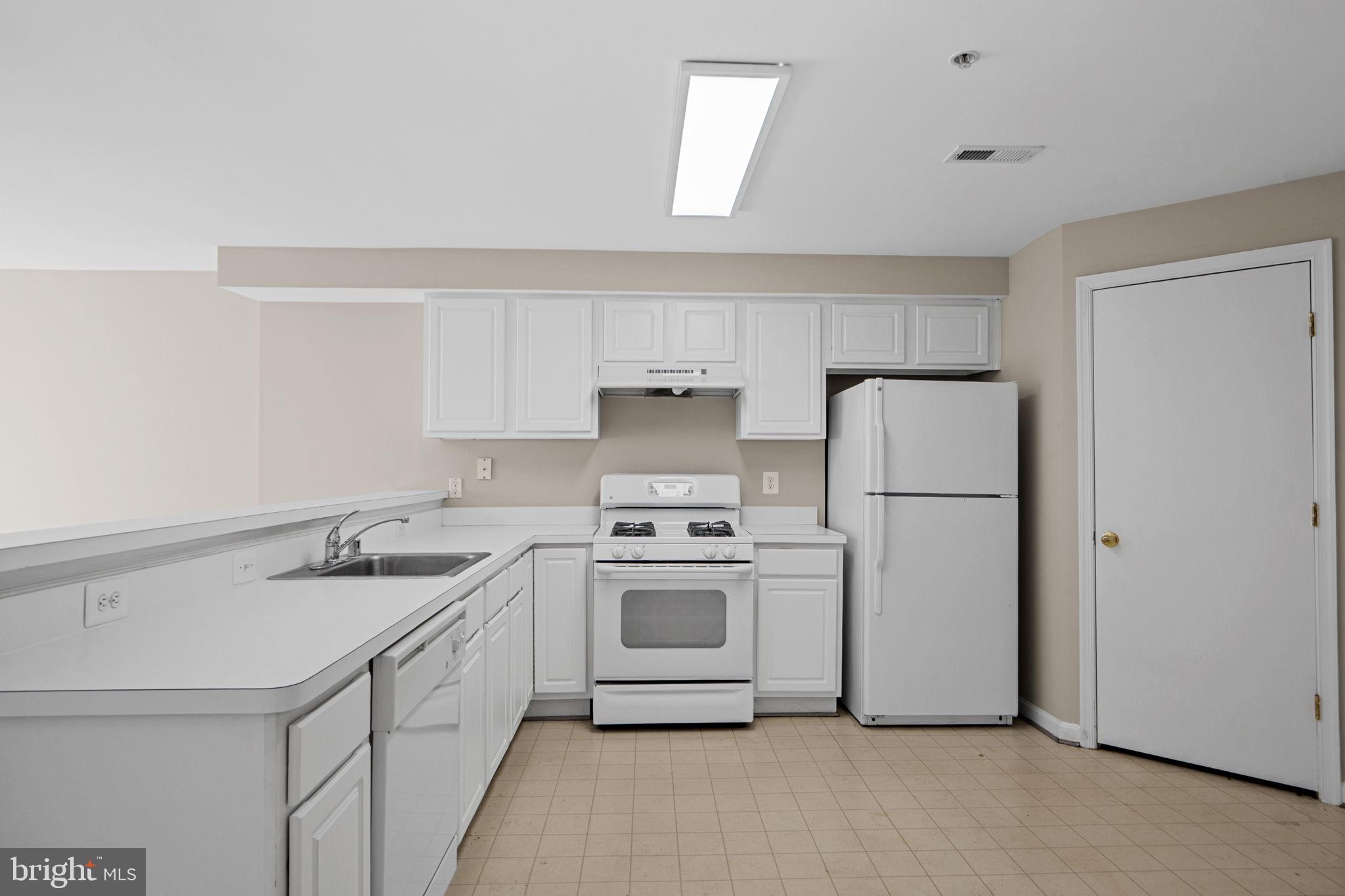 23404 Rainbow Arch Drive, Unit 115 Clarksburg, MD 20871 - Photo 18 of 34 a kitchen with a sink stove and refrigerator