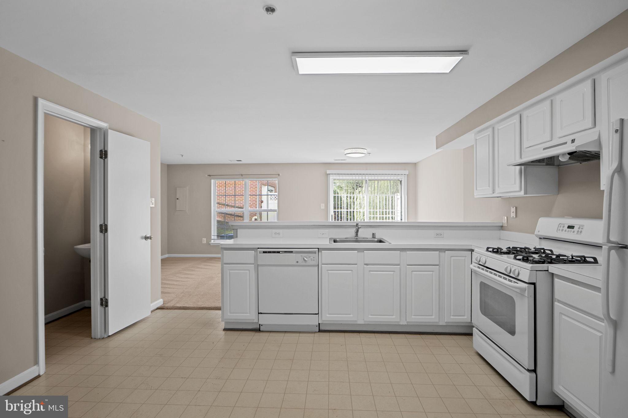 23404 Rainbow Arch Drive, Unit 115 Clarksburg, MD 20871 - Photo 20 of 34 a kitchen with white cabinets and white appliances