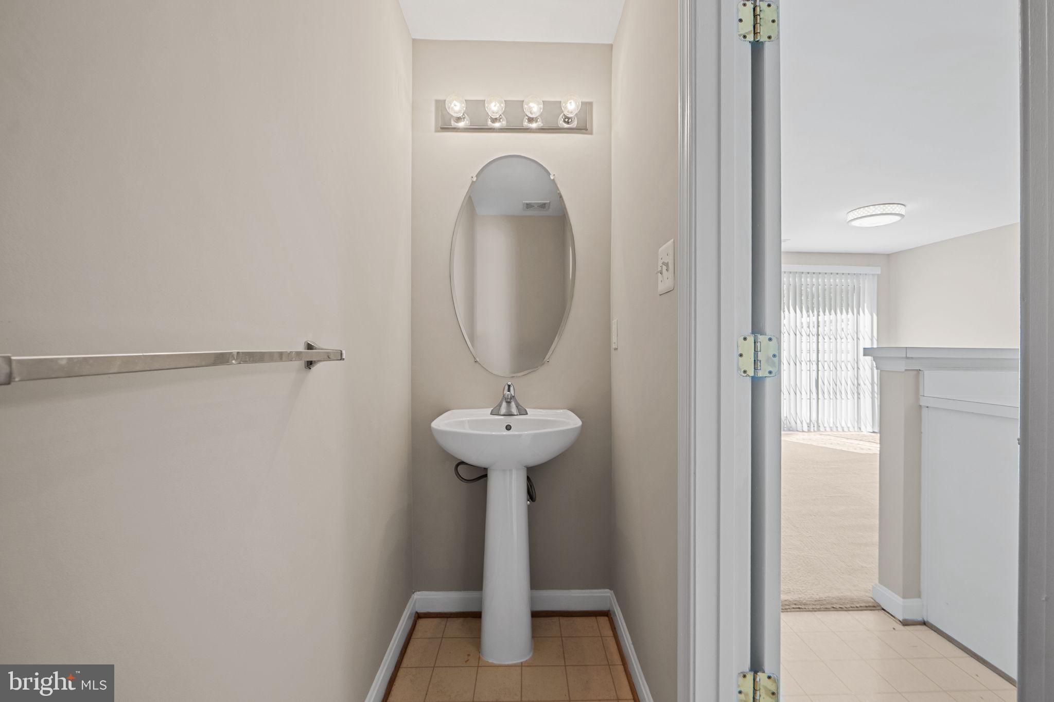 23404 Rainbow Arch Drive, Unit 115 Clarksburg, MD 20871 - Photo 21 of 34 a view of a bathroom with a sink and a mirror