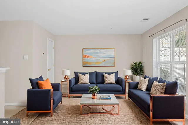 a living room with furniture potted plant and a window