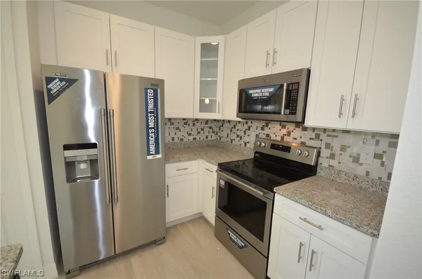 a kitchen with stainless steel appliances granite countertop a refrigerator stove and sink