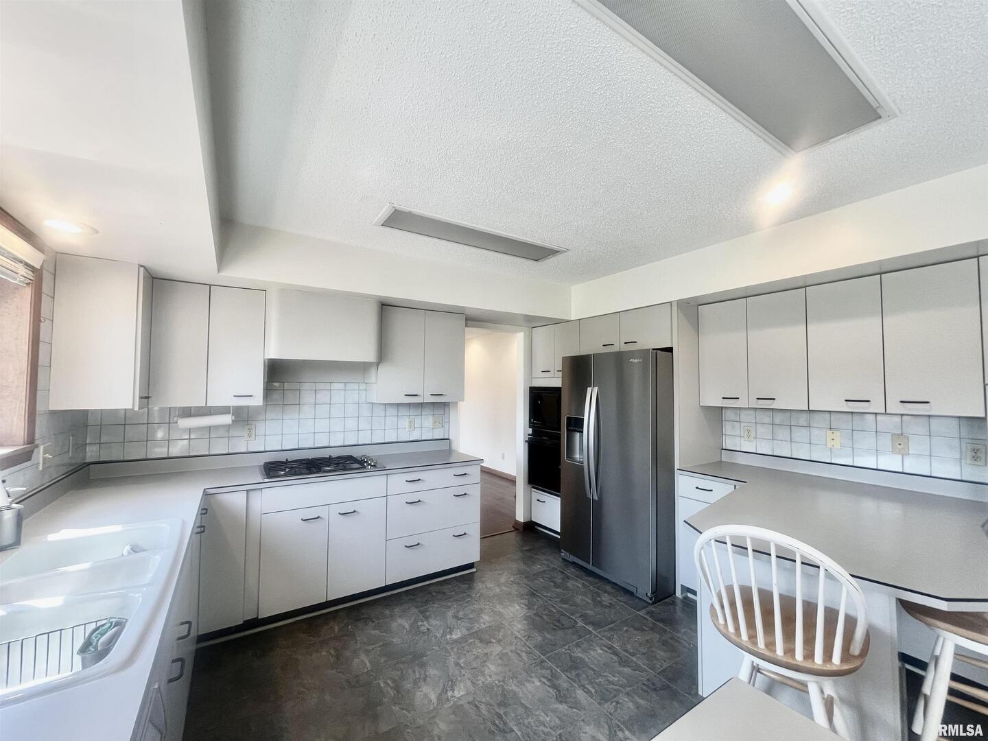 9 Brian Drive Metropolis, IL 62960 - Photo 30 of 71 a kitchen with stainless steel appliances a refrigerator a sink a stove a table and chairs