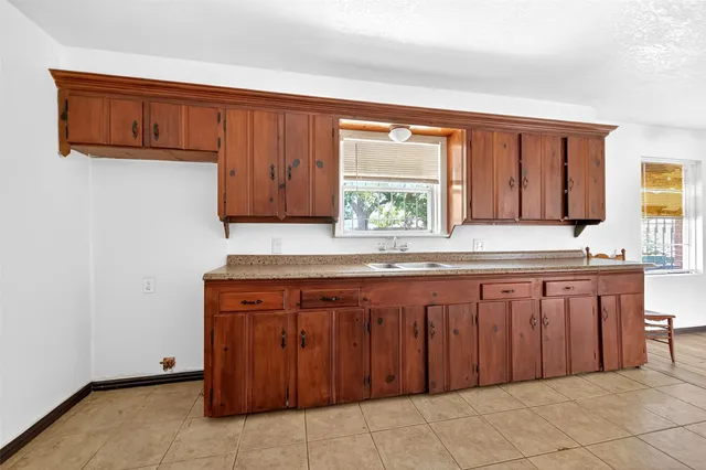 a kitchen with granite countertop wooden cabinets a sink and a window