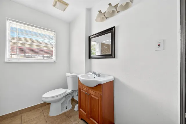 a bathroom with a sink toilet and a mirror