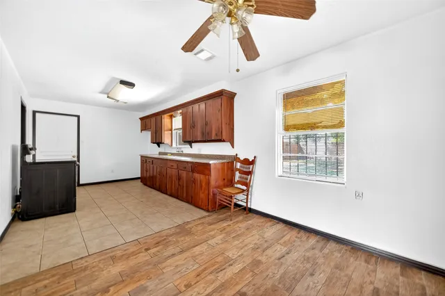 a kitchen with stainless steel appliances a stove top oven a sink a refrigerator cabinets and a window