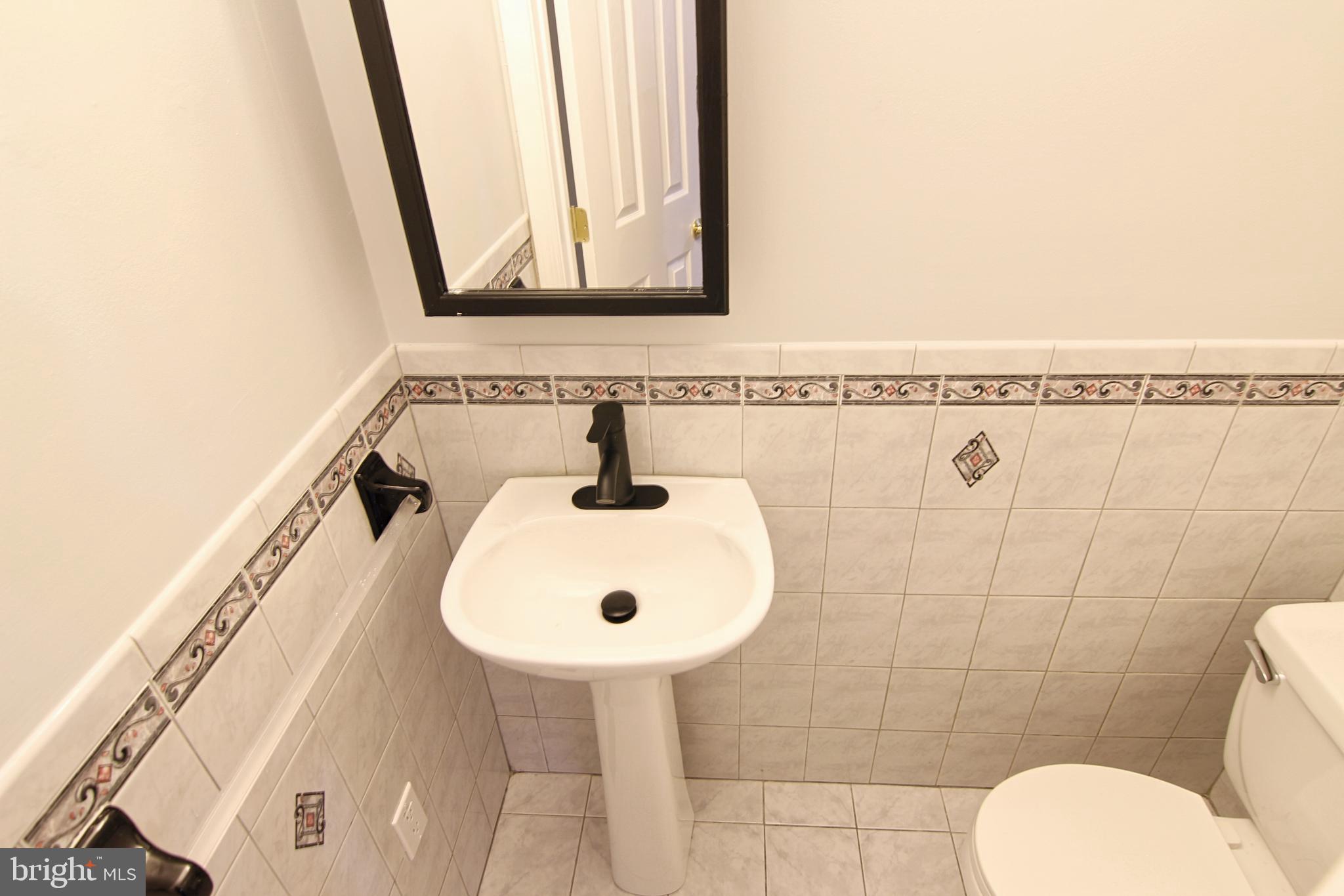 7923-31 Ridge Avenue, Unit 38 Philadelphia, PA 19128 - Photo 8 of 23 a bathroom with a sink mirror and toilet
