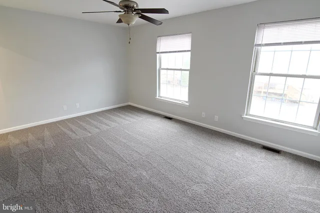 an empty room with windows and closet