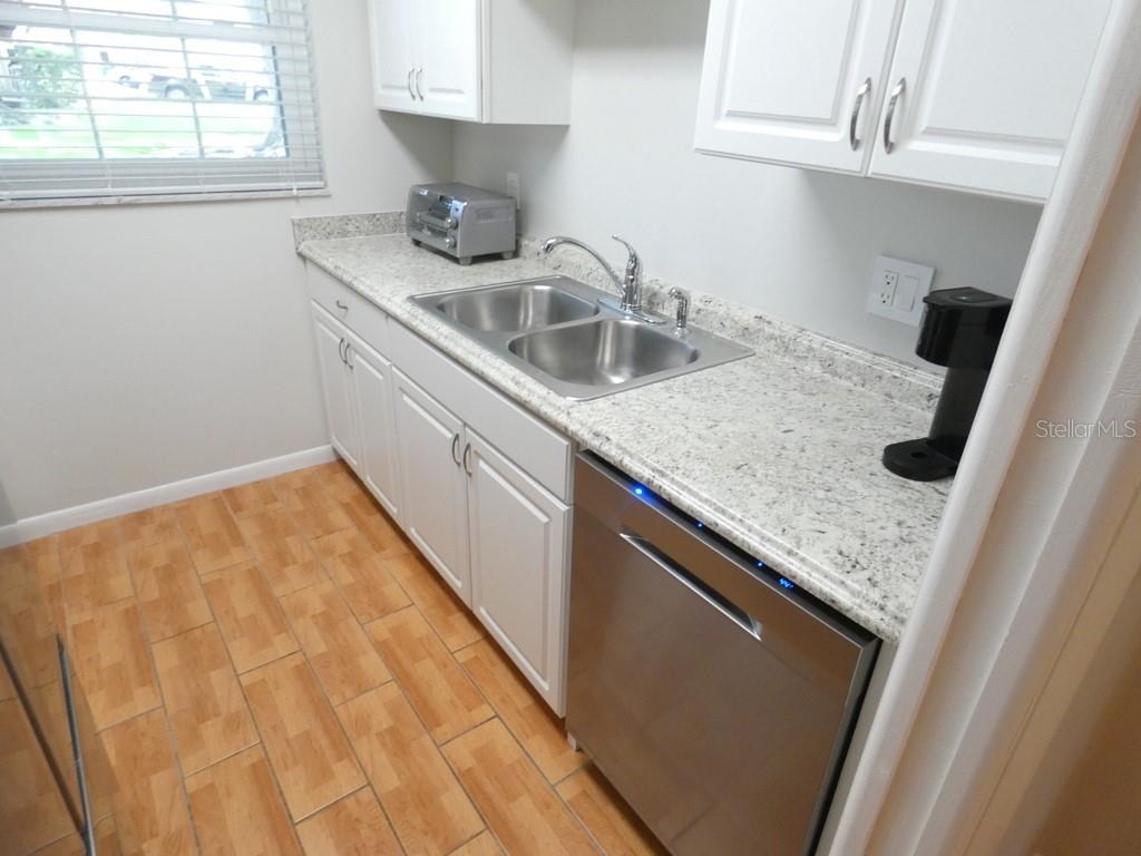 1701 Pinehurst Road, Unit 9G Dunedin, FL 34698 - Photo 10 of 22 a kitchen with a sink a window and cabinets