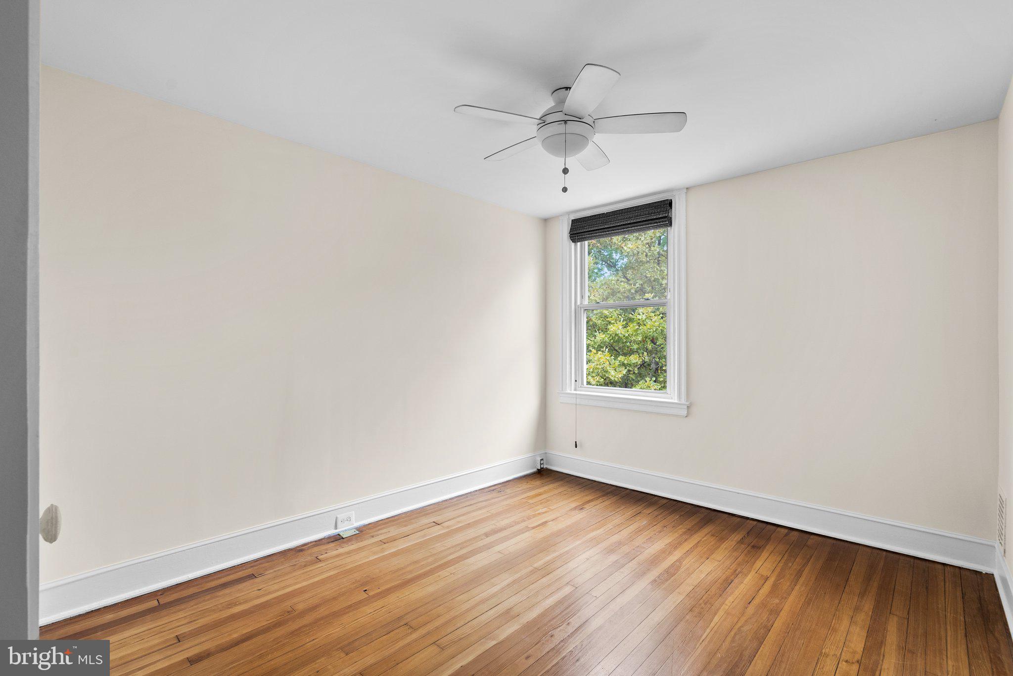 121 U Street Northeast Washington, DC 20002 - Photo 12 of 31 an empty room with wooden floor chandelier fan and windows