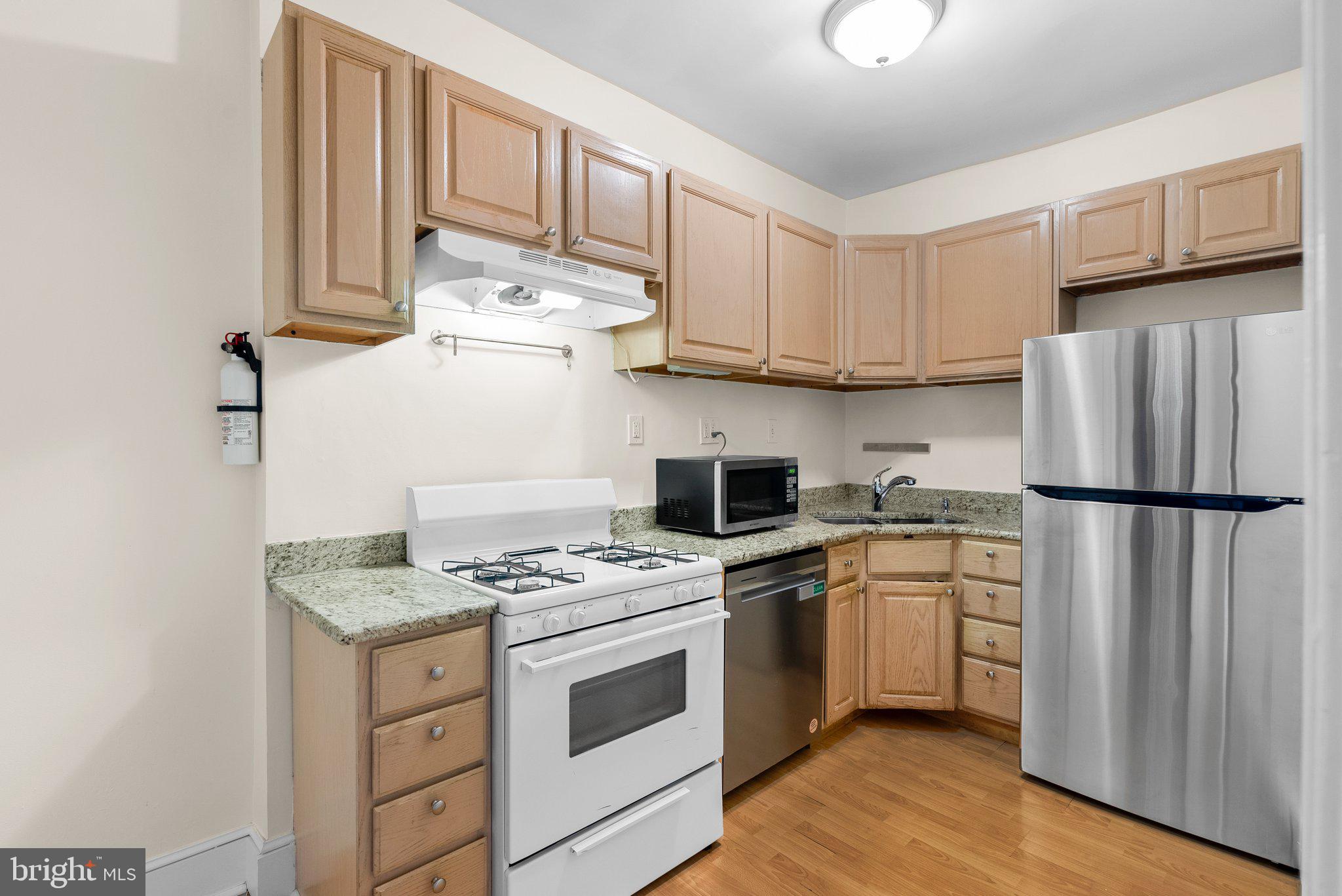 121 U Street Northeast Washington, DC 20002 - Photo 8 of 31 a kitchen with stainless steel appliances granite countertop a refrigerator sink stove and cabinets