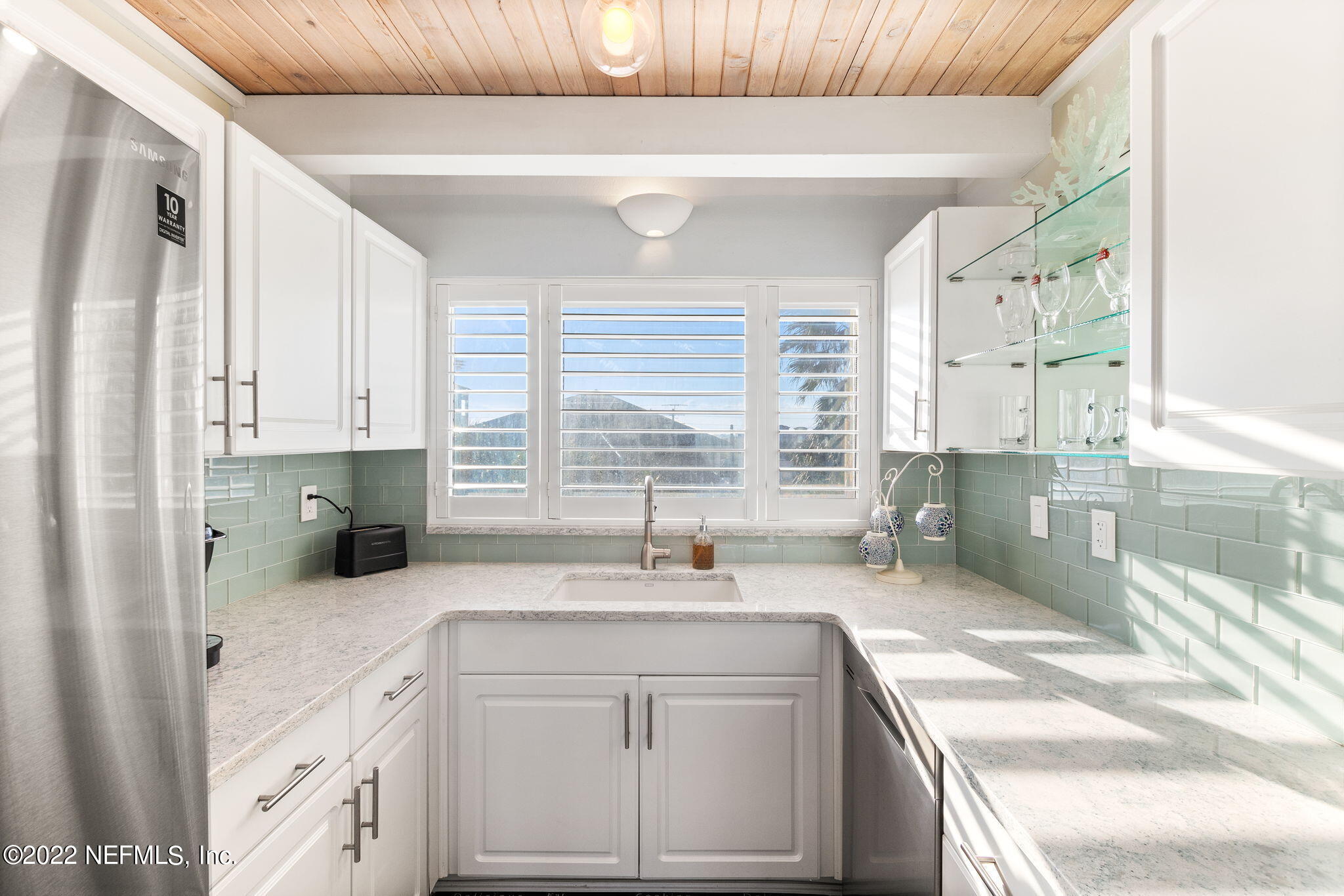 5725 Rudolph Avenue St. Augustine, FL 32080 - Photo 22 of 94 a bathroom with a granite countertop sink a large mirror and a bathtub next to a window