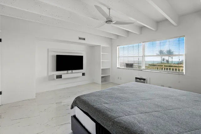 a room with a bed and a ceiling fan