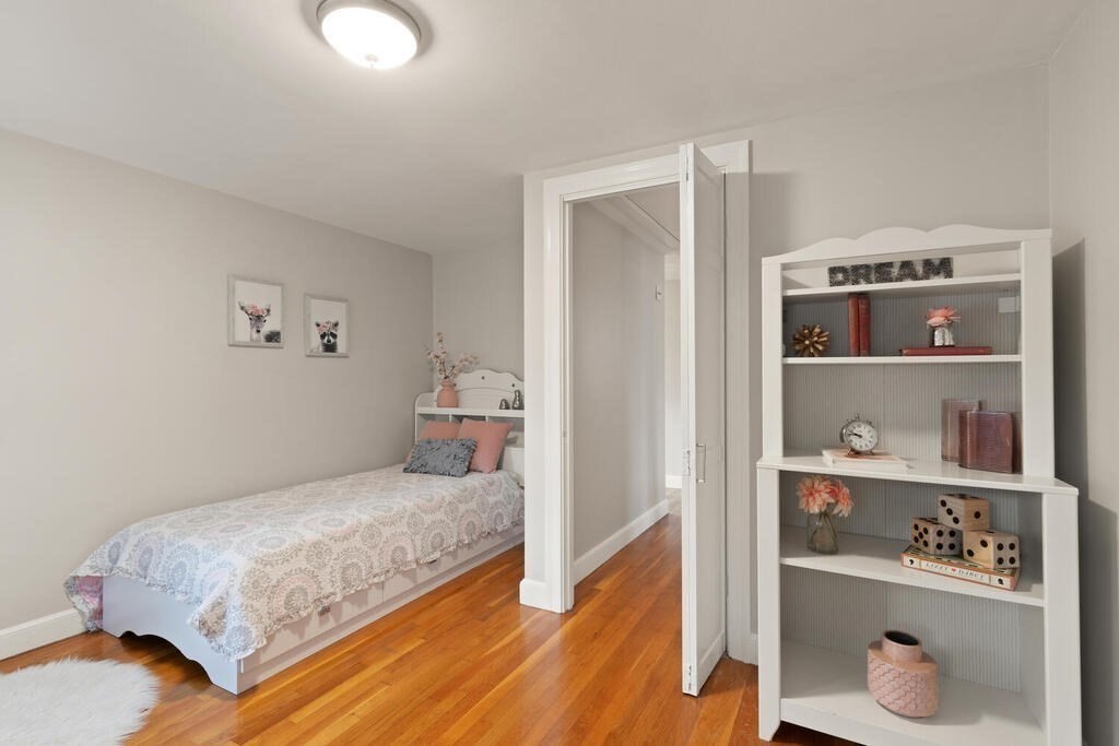 39 Nathaniel Road Winchester, MA 01890 - Photo 19 of 38 a bedroom with a bed and a shelf with wooden floor