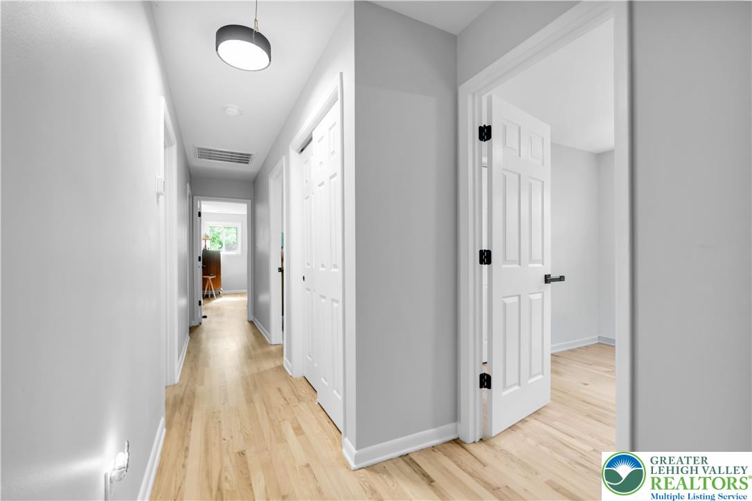 2011 Greenwood Road Allentown, PA 18103 - Photo 23 of 52 Blonde wood flooring creates a welcoming ambiance throughout this clean hallway, guiding the eye to bright rooms beyond.