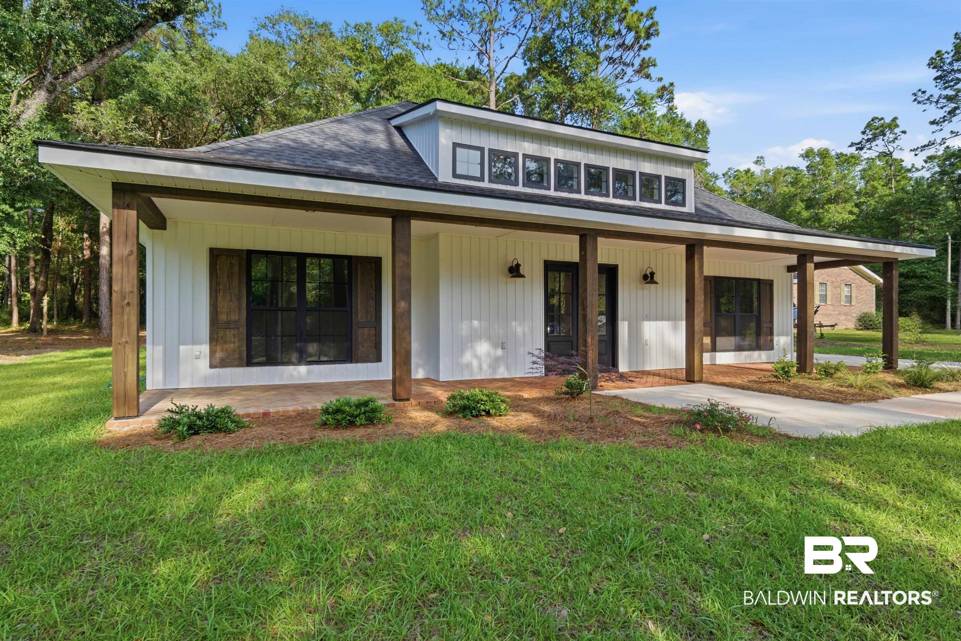 14128 Jackson Lane Foley, AL 36535 - Photo 1 of 36 White board-and-batten siding with dark window frames and rustic wood shutters