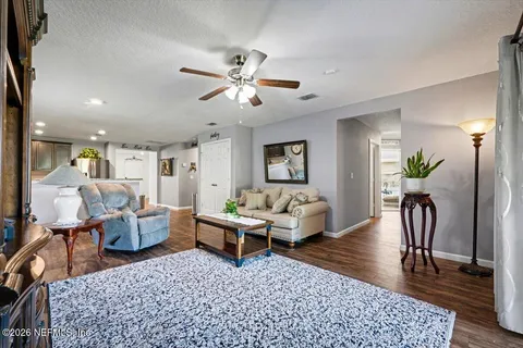 a living room with furniture and a wooden floor