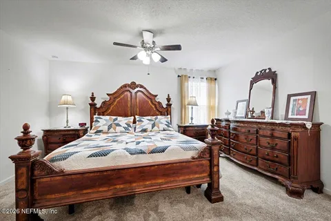 a bedroom with a bed a chandelier and dresser