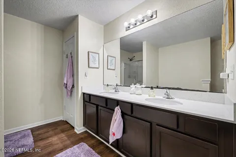 a en suite bathroom with a double vanity sink and a mirror