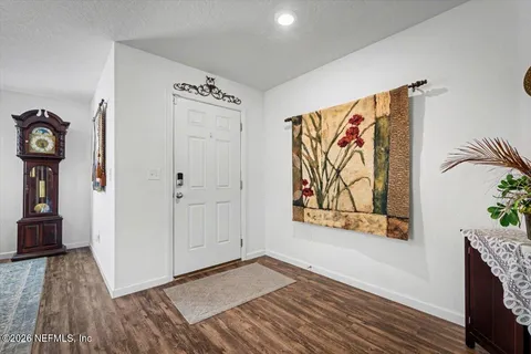 a view of a hallway with wooden floor and a bookshelf