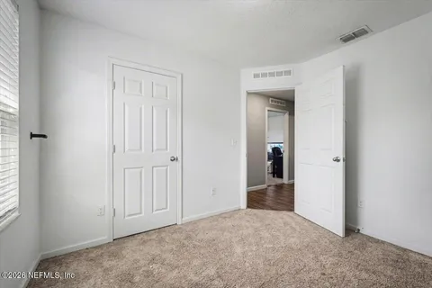 an empty room with windows and closet