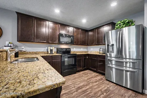 a kitchen with kitchen island granite countertop stainless steel appliances and wooden cabinets