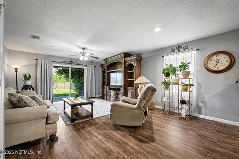a living room with furniture a clock and a large window