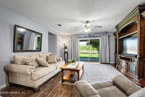 a living room with furniture a flat screen tv and a large window