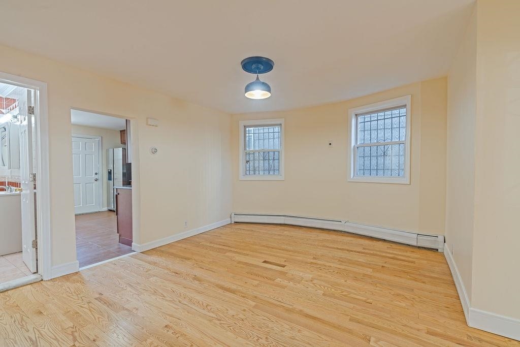 337 Summit Avenue, Unit 1 Jersey City, NJ 07306 - Photo 3 of 26 a view of an empty room with wooden floor and a window