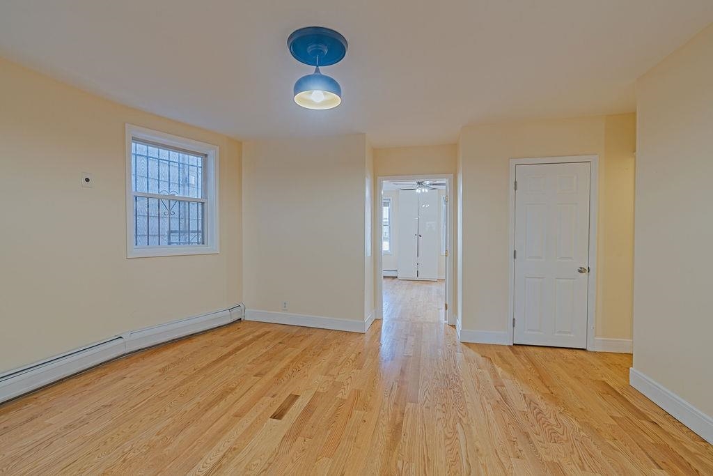 337 Summit Avenue, Unit 1 Jersey City, NJ 07306 - Photo 4 of 26 an empty room with wooden floor and windows