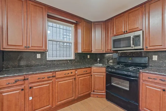 a kitchen with granite countertop cabinets stainless steel appliances and a sink