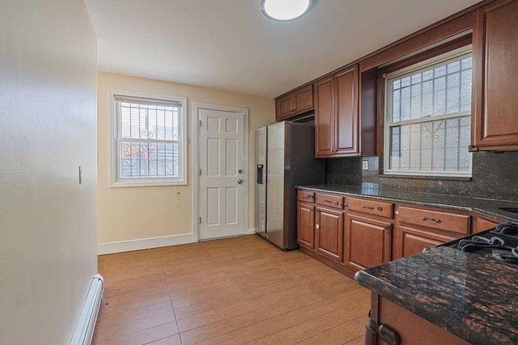 337 Summit Avenue, Unit 1 Jersey City, NJ 07306 - Photo 6 of 26 a kitchen with stainless steel appliances granite countertop a stove a sink dishwasher a microwave oven and a refrigerator with wooden cabinets