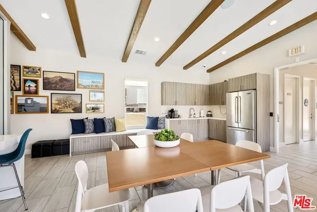 a view of a dining room with furniture a kitchen and chandelier