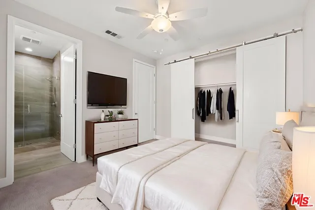 a bedroom with a bed and a flat screen tv