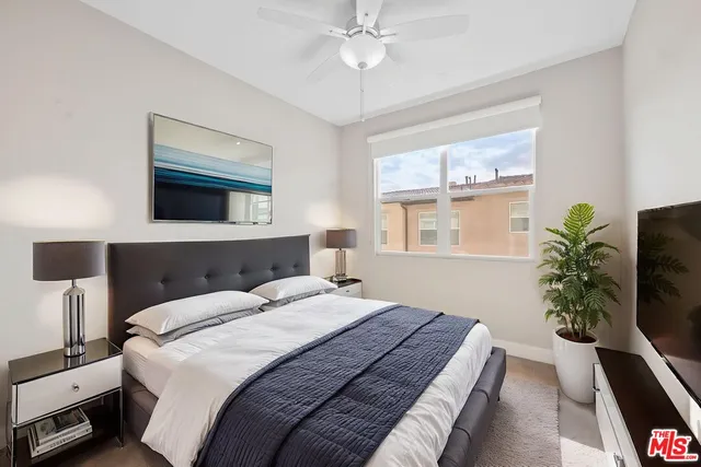 a bedroom with a bed and a potted plant