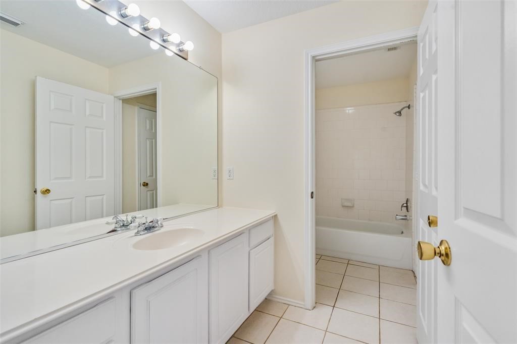11011 Hunting Path Court Houston, TX 77065 - Photo 22 of 31 a bathroom with a sink a mirror and a bathtub