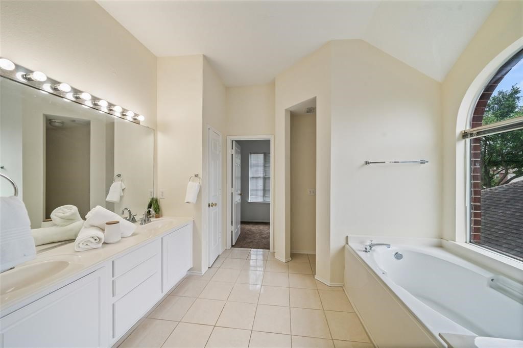 11011 Hunting Path Court Houston, TX 77065 - Photo 27 of 31 a spacious bathroom with a double vanity sink a mirror and a bathtub