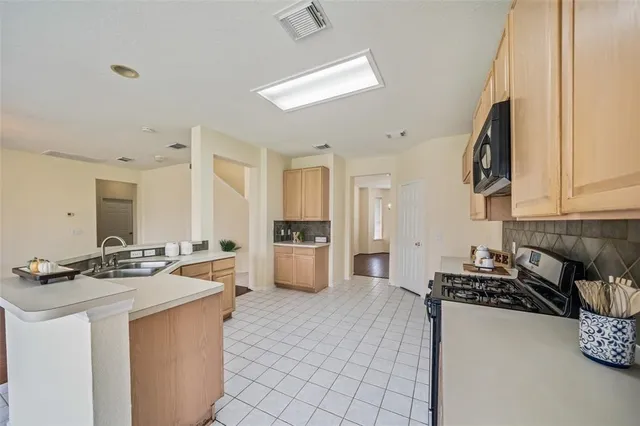 a kitchen with stainless steel appliances a stove a sink a refrigerator a counter top space and cabinets