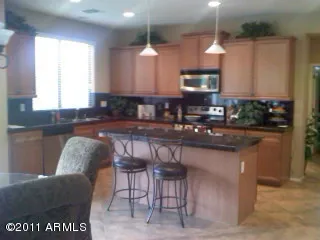 a kitchen with stainless steel appliances granite countertop a table and chairs in it