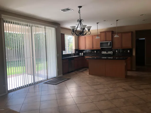 a kitchen with stainless steel appliances granite countertop a stove a sink a counter space and cabinets